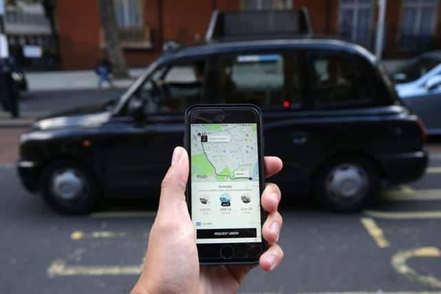 A smartphone is used to order an Uber in London. Picture: Daniel Leal