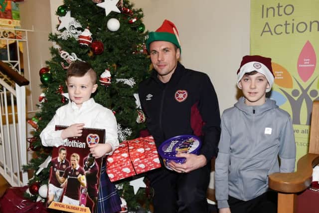 Hearts midfielder Don Cowie is pictured with Quinn Martin (4) and Shayne McKenzie (12) on a visit to Edinburghs Royal Hospital for Sick Children yesterday.