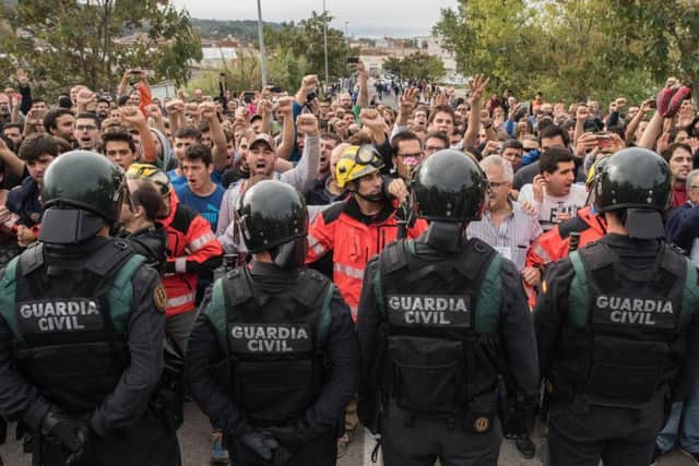 Riot police are confronted by an angry crowd in Catalonia after officers confiscated ballot boxes during the controversial referendum on independence (Picture: Getty)