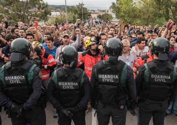 Riot police are confronted by an angry crowd in Catalonia after officers confiscated ballot boxes during the controversial referendum on independence (Picture: Getty)