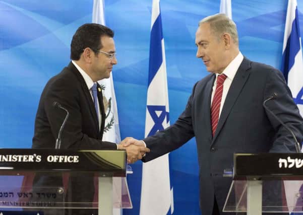 Jimmy Morales, left, and Benjamin Netanyahu shake hands. Picture: ABIR SULTAN/AFP/Getty Images