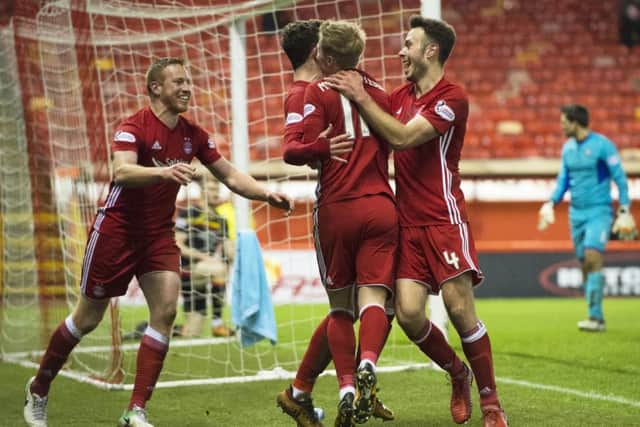 Aberdeen striker Adam Rooney, left, celebrates with team-mates after scoring the only goal of the game at Pittodrie.