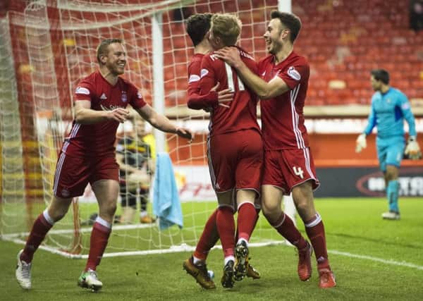 Aberdeen striker Adam Rooney, left, celebrates with team-mates after scoring the only goal of the game at Pittodrie.