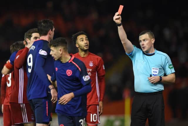 Referee John Beaton shows the red card to Hearts' Kyle Lafferty (left). Picture: SNS