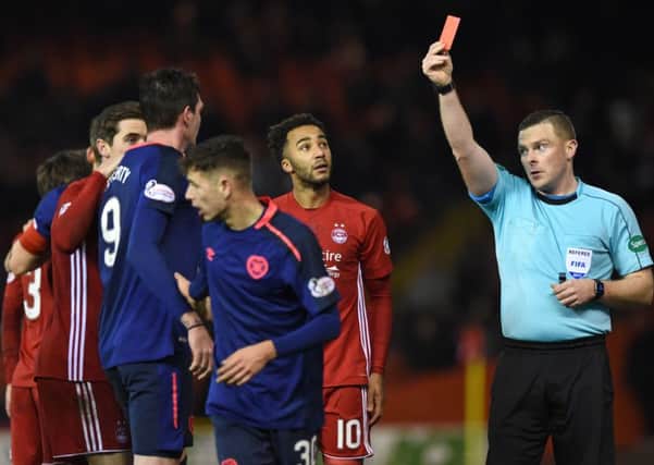 Referee John Beaton shows a red card to Hearts Kyle Lafferty following his scything tackle on Aberdeens Graeme Shinnie. Picture: SNS.