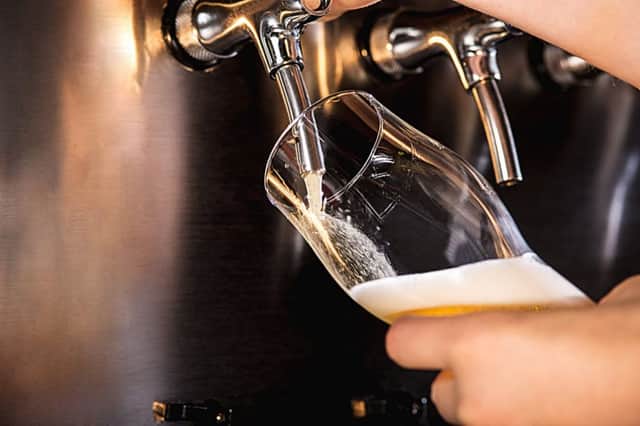 A bartender pours a large lager beer on tap. Pubs were hit by poor sales across Scotland over Christmas