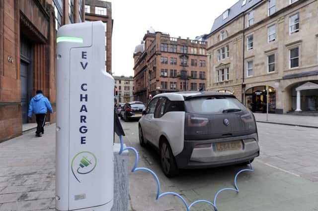 An electric vehicle at a public charging point in Glasgow. Sales of cars that burn fossil fuels are due to be phased out in Scotland by 2032. Picture: John Devlin/TSPL
