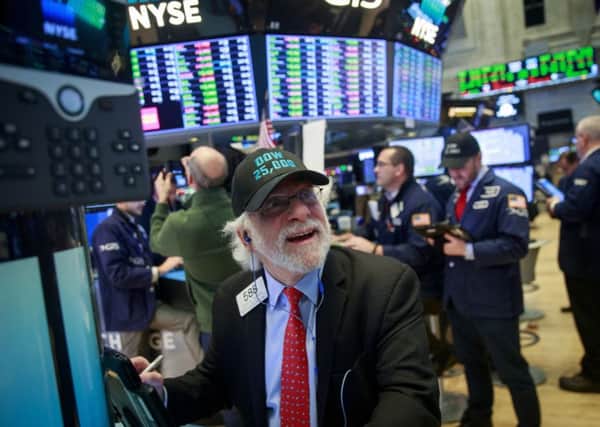 A trader is all smiles on the floor of the New York Stock Exchange as the Dow Jones Index closed above 25,000 for the first time ever on Thursday. Picture: Drew Angerer/Getty Images