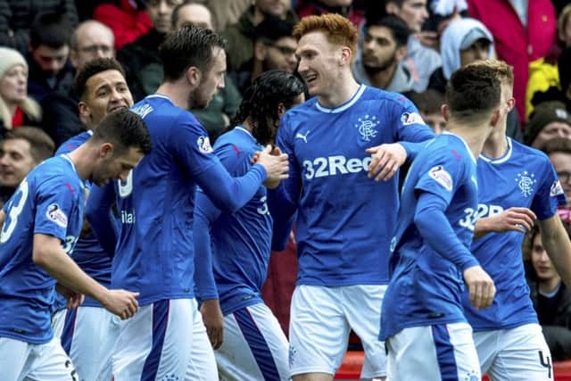 David Bates congratulates Wilson, who has taken on the role of mentoring the young defenders at Rangers. Picture: SNS Group