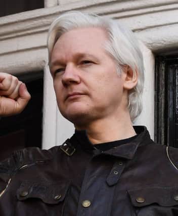Wikileaks founder Julian Assange raises his fist prior to addressing the media on the balcony of the Embassy of Ecuador in London in May last year. 
Picture: Justin Tallis