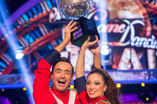 Joe McFadden and dance partner Katya Jones raise the Strictly Come Dancing Glitterball trophy