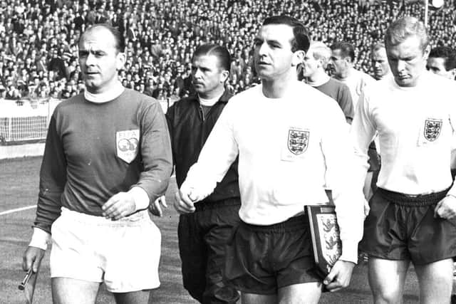 FILE - This is a Oct. 23, 1963 file photo of England captain Jimmy Armfield, front right, leading out England for the match against the Rest of the World led by Alfredo Di Stefano, front left, for the Football Association Centenary soccer match at Wembley Stadium, London. Jimmy Armfield, a former England captain who led Leeds to the European Cup final as a manager before a distinguished career in broadcasting, died Monday Jan. 22, 2018. He was 82. (AP Photo/File)