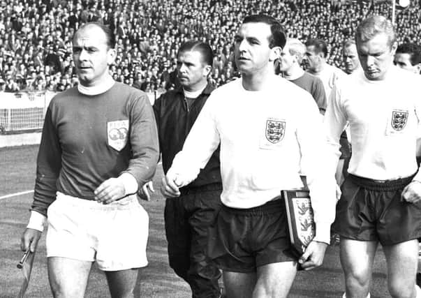 FILE - This is a Oct. 23, 1963 file photo of England captain Jimmy Armfield, front right,  leading out England for the match against the Rest of the World led by Alfredo Di Stefano, front left,  for the Football Association Centenary soccer match at Wembley Stadium, London.  Jimmy Armfield, a former England captain who led Leeds to the European Cup final as a manager before a distinguished career in broadcasting,  died Monday Jan. 22, 2018. He was 82. (AP Photo/File)