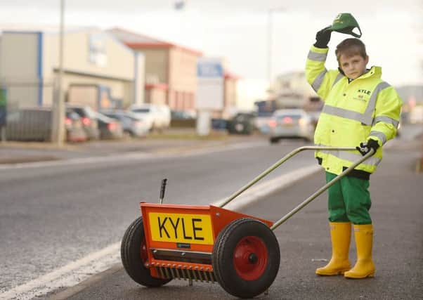 Kyle Mackay, 8, of Kiltarlity with his new grit spreader, Picture: SWNS