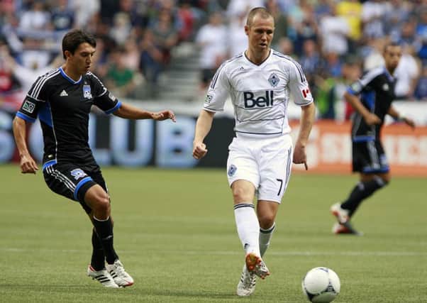 Kenny Miller of Vancouver Whitecaps holds off Shea Salinas of San Jose Earthquakes during an MLS clash in July 2012. Picture: Getty Images