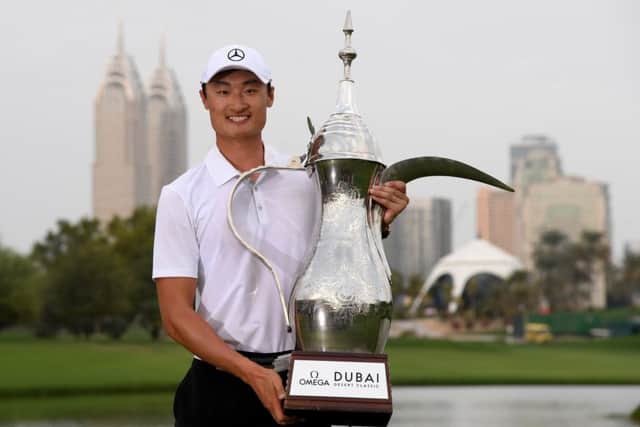 China's Haotong Li gets his hands on the iconic trophy after becoming the first Asian player to win the Omega Dubai Desert Classic. Picture: Getty Images