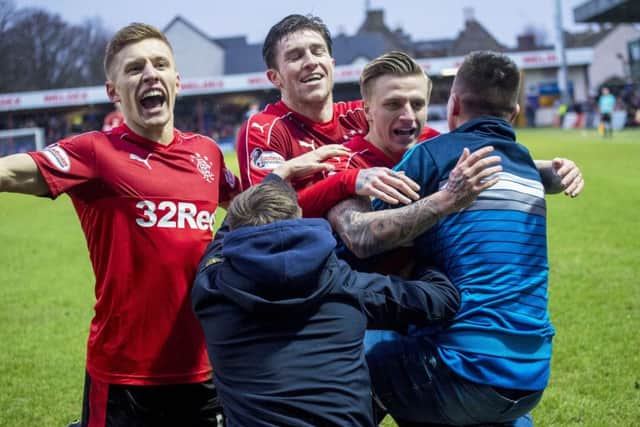 Jason Cummings, right, is mobbed by Rangers supporters after scoring his first goal for the club. Picture: SNS