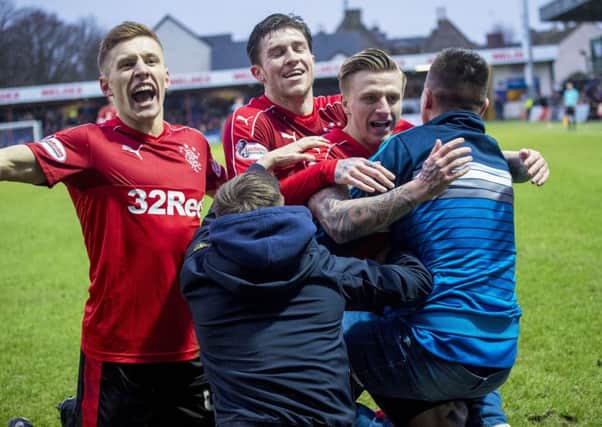 Jason Cummings, right, is mobbed by Rangers supporters after scoring his first goal for the club. Picture: SNS