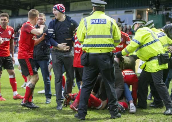 Police move to clear fans celebrating Jason Cummings goal off the pitch. Picture: PA.