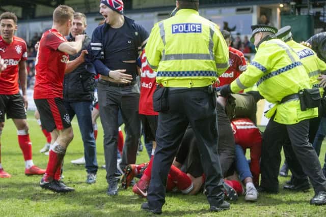 Police move to clear fans celebrating Jason Cummings goal off the pitch. Picture: PA.