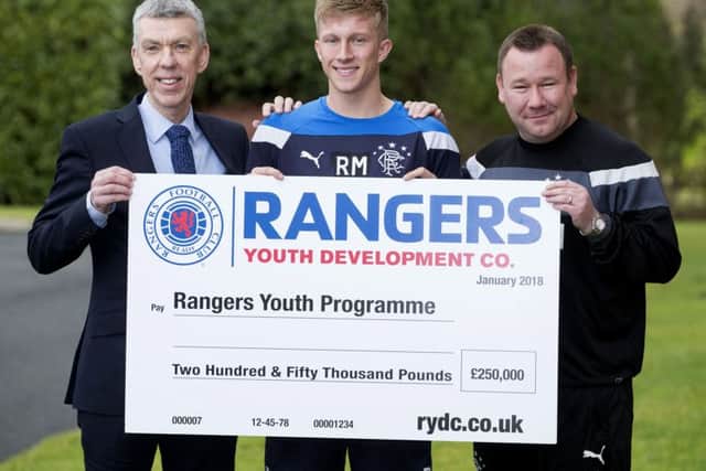 Colin Stewart, the Rangers Youth Development Company director of operations, Rangers' Ross McCrorie and Craig Mulholland, Rangers Head of Academy with a cheque for £250.000. Picture: Ross Brownlee/SNS