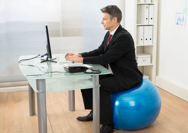 There's increasing evidence that sitting down is bad for you. Would a pilates ball help or should we adopt standing desks?