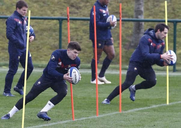 Matthieu Jalibert, left, runs with the ball during a France training session. Picture: Michel Euler/AP