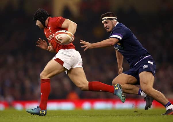 Stuart McInally chases after Wales' Leigh Halfpenny during Saturday's match. Picture: PA