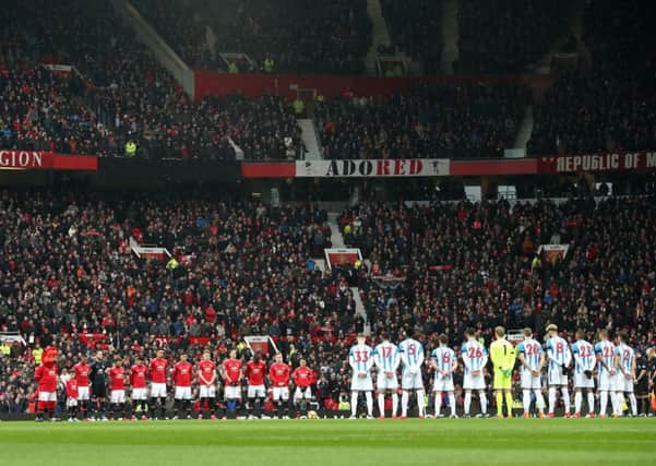Players of Manchester United and Huddersfield Town line up for a minutes silence in tribute to victims of the Munich air disaster ahead of the Premier League match at Old Trafford last Saturday. Picture: PA.