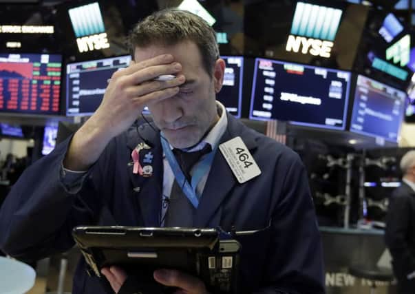 Trader Gregory Rowe on the floor of the New York Stock Exchange as shares slumped in value (Picture: AP)