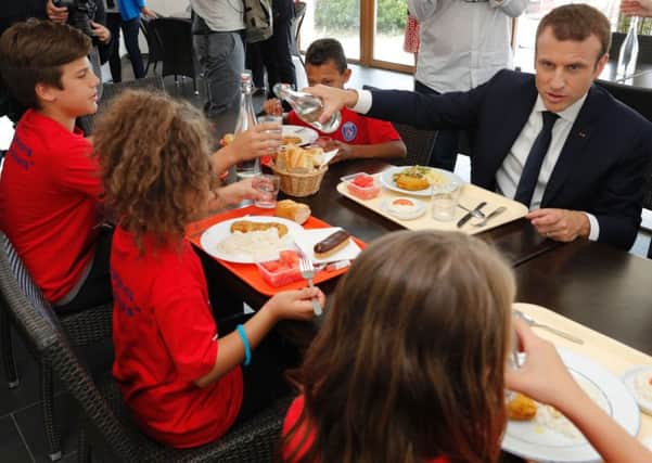 French President Emmanuel Macron shares a lunch with young children (Picture: AFP/Getty)