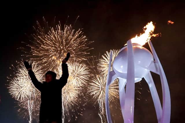 Fireworks erupt as the cauldron is lit with the Olympic flame. Picture: David J. Philip/AFP/Getty Images