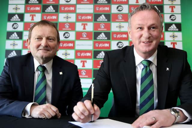 Northern Ireland manager Michael O'Neill, right, signs his new contract with Irish FA President David Martin. Picture: Brian Lawless/PA Wire