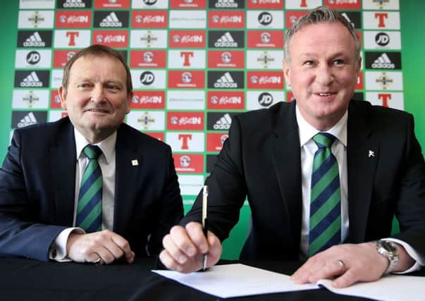 Northern Ireland manager Michael O'Neill, right, signs his new contract with Irish FA President David Martin. Picture: Brian Lawless/PA Wire