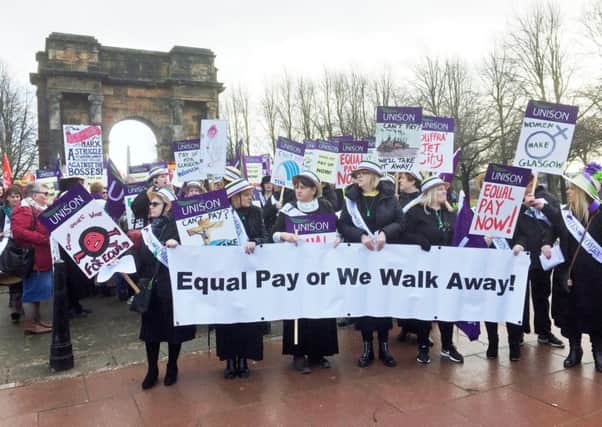 Hundreds of women, some dressed as suffragettes, march through Glasgow calling for equal pay from the city council. Picture: PA
