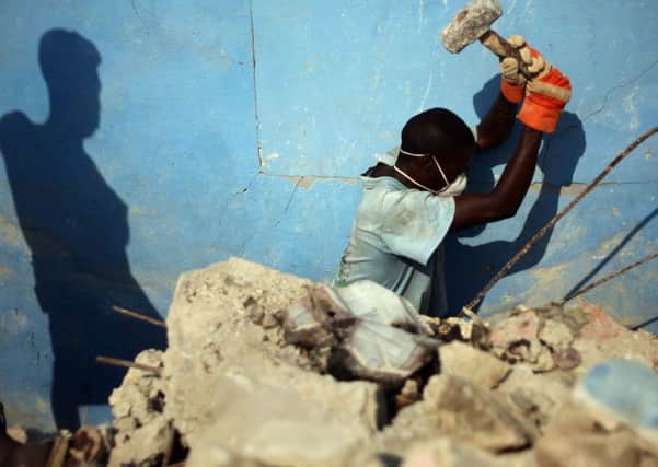 Residents clean up the debris in a house in Port-au-Prince. Oxfam has denied it covered up the use of prostitutes by aid workers in Haiti. Photograph: Hector Retamal/AFP/Getty Images