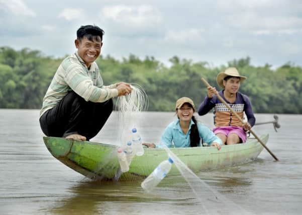 Fishing in the Sekong River are Lang Phong, daughter Thongtheng and son Nuden.