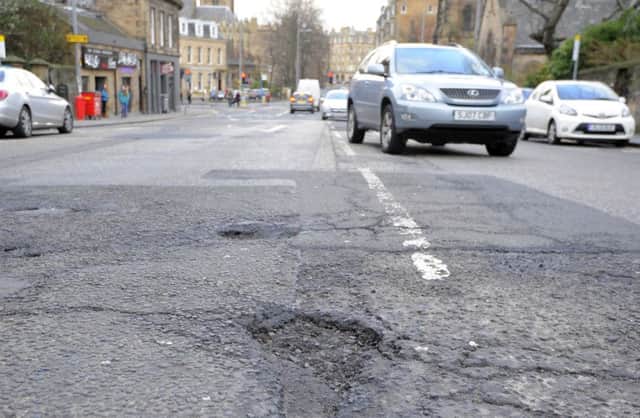A pot hole in Edinburgh's Morningside Road. Scottish councils are spending less on road maintenance, a report has found. Picture: Neil Hanna