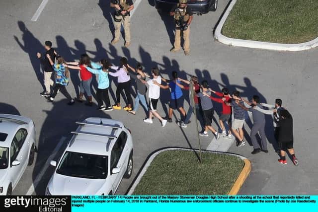 People are brought out of the Marjory Stoneman Douglas High School after a shooting at the school