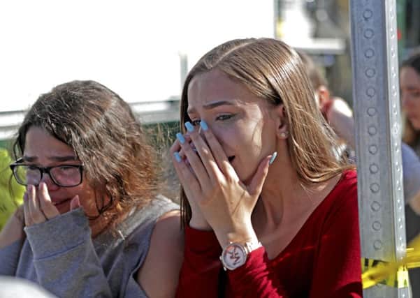 Students released from a lockdown are overcome with emotion following following a shooting at Marjory Stoneman Douglas High School. Picture; AP