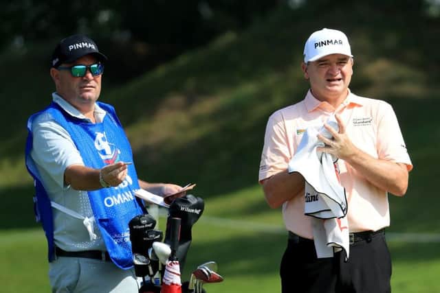 Paul Lawrie and new caddie Damian Moore talk over a shot during the first round in the NBO Oman Open. Picture: Getty Images