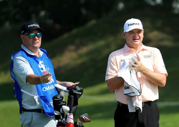 Paul Lawrie and new caddie Damian Moore talk over a shot during the first round in the NBO Oman Open. Picture: Getty Images