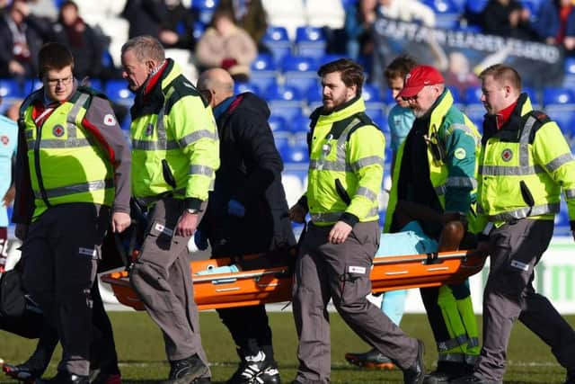 Hearts midfielder Arnaud Djoum is stretchered off in pain