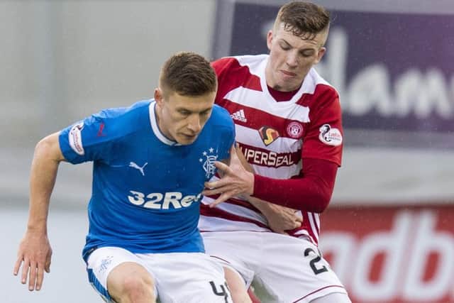 Lewis Ferguson battles with his former team-mate Greg Docherty. Picture: SNS