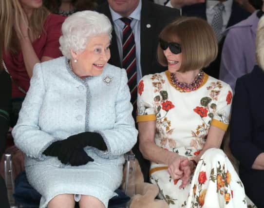 Queen Elizabeth II sits next to Anna Wintour (right) as they view Richard Quinn's runway show at London Fashion Week. Picture:  Yui Mok/PA Wire