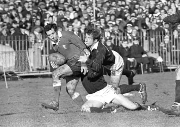 Ian Robertson hangs on to Wales captain Gareth Edwards at Cardiff Arms Park in 1970. Picture:, PA Archive