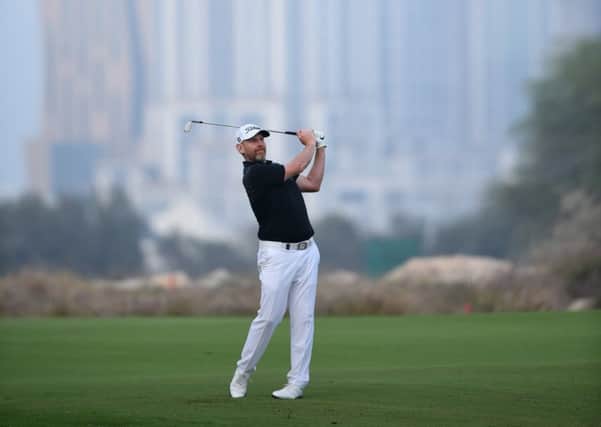 Stephen Gallacher hits his approach shot on the 18th hole in the second round of the Qatar Masters. Picture: Tom Dulat/Getty