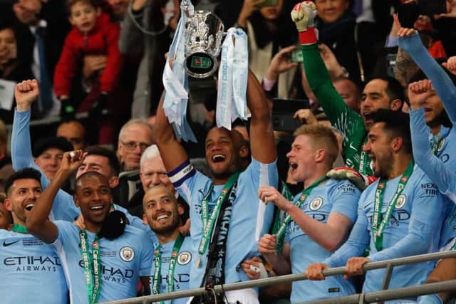 Captain Vincent Kompany lifts the League Cup after Manchester City earned Pep Guardiola, below, his first trophy in English football. Picture: Getty.