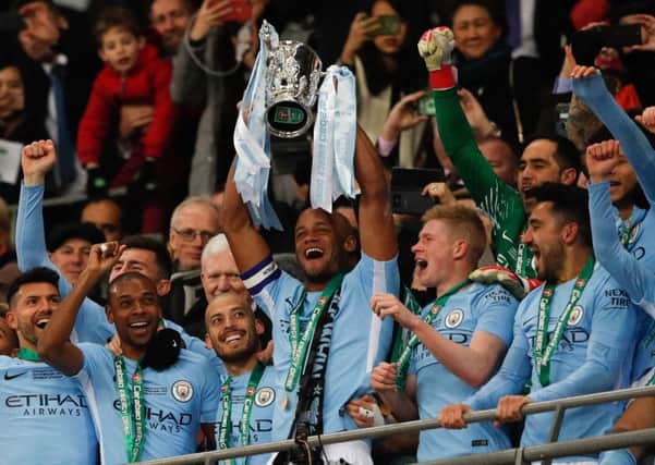 Captain Vincent Kompany lifts the League Cup after Manchester City earned Pep Guardiola, below, his first trophy in English football. Picture: Getty.
