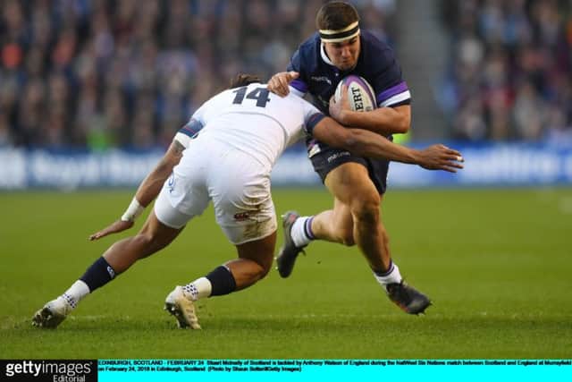 Scotland hooker Stuart McInally is tackled by England's Anthony Watson at Murrayfield.